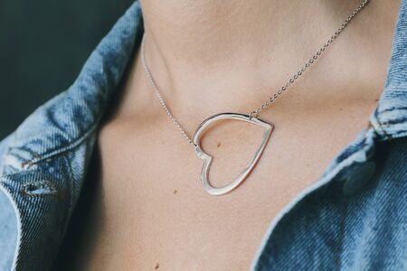 Tender jewelry on female neck, close up shot. Elegance accessories for look and beauty. Chain-let with pendant on neck, soft light. Gift for relationship. Fashion, love concept.の写真素材