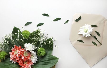 Beautiful spring flowers bouquet with envelope for greetings isolated on white