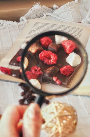 Find the dream of day. Crafted handmade chocolate bar with marshmallow and berries, coffee beans and good book. Best combination for being at home for long. Tasty, sweet, delicious dessert.の写真素材