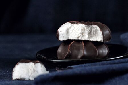 Taste and smell. Close up of chocolate fresh marshmallows, design food, dark mood on black...