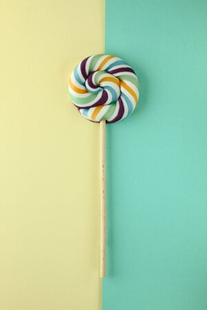 Art composition, design food - colorful candy, sweets as sunshine isolated on bicolored green and...