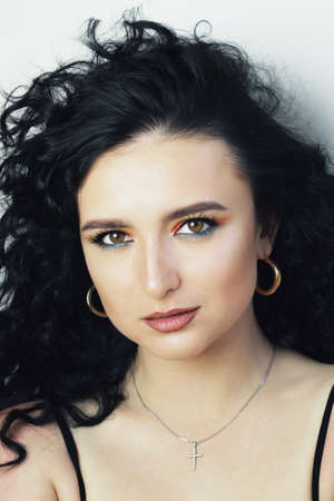 Smoky. Beautiful young brunette model with bright make-up and curly hairstyle. Fashion and beauty, using cosmetics. Vibrant colors of eyeshadow and lipstick. Saloon, make up artist, caucasian model.の写真素材