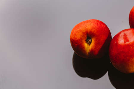few nectarines on a dark mirror background.の写真素材