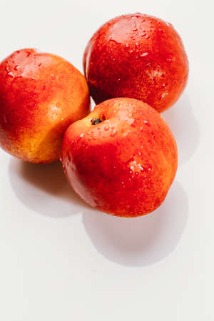 few nectarines on a white mirror background.の写真素材