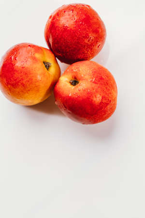 few nectarines on a white mirror background.の写真素材