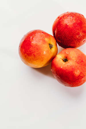 few nectarines on a white mirror background.の写真素材