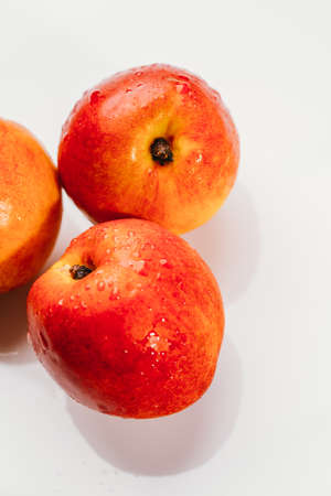 few nectarines on a white mirror background.の写真素材