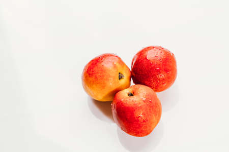few nectarines on a white mirror background.の写真素材