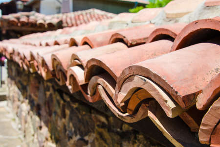 Close up of stone fence covered with roof clay tiles in Sozopol, Bulgariaの写真素材