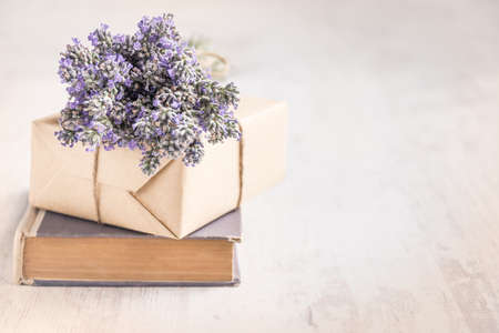 Lavender bouquet laid over  an old book on a white wooden background. Vintage style.の写真素材