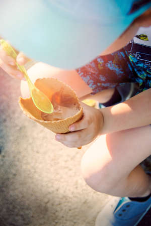 Little boy eating a cone with chocolate icecreamの写真素材