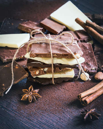 A tower of chocolate bars wrapped like a chocolate present . Various chocolate pieces, spices,cocoa...