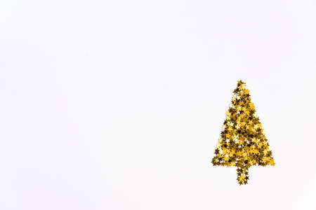 Christmas tree made of gold star shaped sequins. White background, copy space.の写真素材