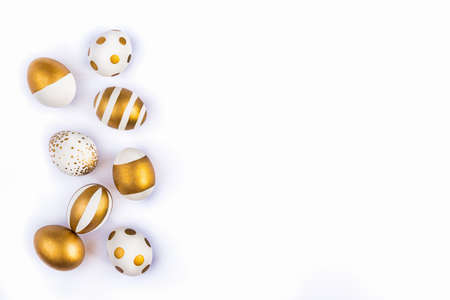 Top view of easter eggs colored with golden paint in differen patterns. Various striped and dotted designs. White background. Copy space.の写真素材