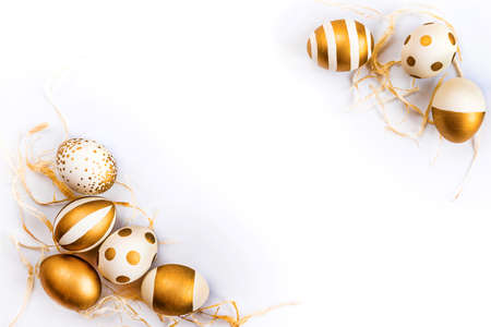 Top view of easter eggs colored with golden paint in differen patterns. Various striped and dotted designs. White background. Copy space.の写真素材