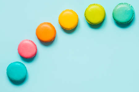 Colorful macaroons arranged like rainbow over blue background.の写真素材