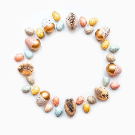 Top view of easter eggs colored with golden paint in differen patterns arranged in circle. White...