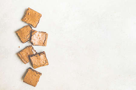 Top view of freshly baked home made brownie cake cut in squares over white rustic background. Copy space.の写真素材