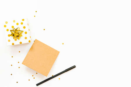 Top view of golden dotted gift boxes and empty card on a white background. Copy space, mock-up.