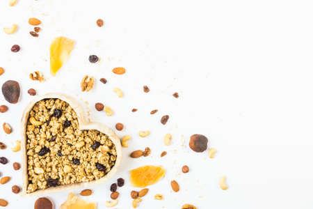 Top view of a heart shaped bow full of crunchy granola. Healthy eating concept. Copy space.の写真素材