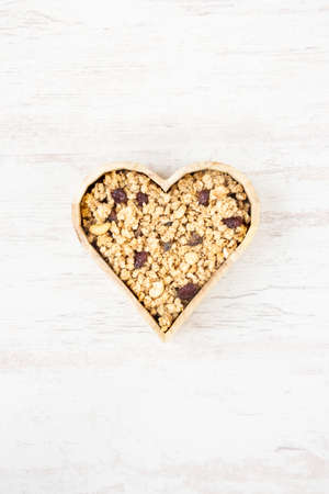 Top view of a heart shaped bow full of crunchy granola. Healthy eating concept.の写真素材