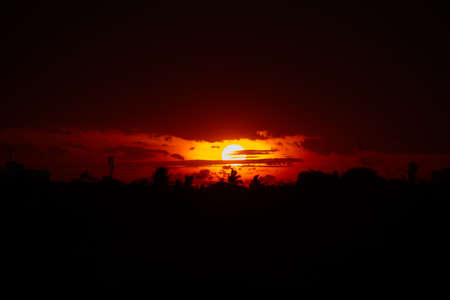 orange sun dark sky with sillhoutte background