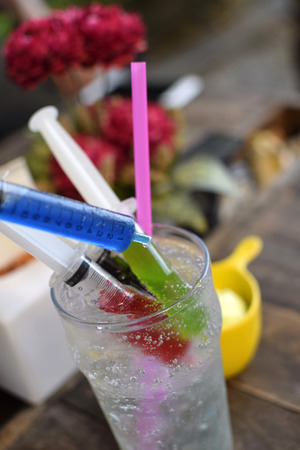 Iced blue soda with colorful syringesの写真素材