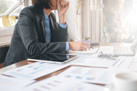 Asian business woman working and analysis graph and chart on table with computer notebookの写真素材