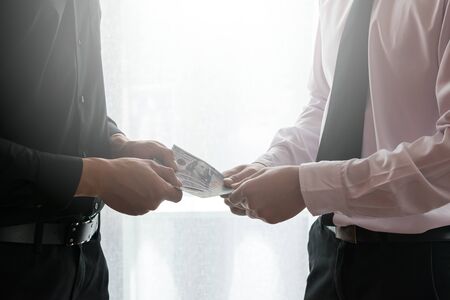 Two business man dealing with handing moneyの写真素材