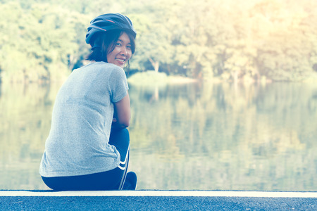 Asian Sport Woman with Cycling Helmet Acting near the Lagoonの写真素材