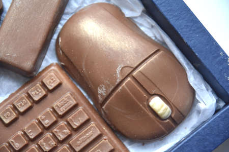 Top view of chocolate cake in form of keyboard and mouse with game controller in rectangular box...
