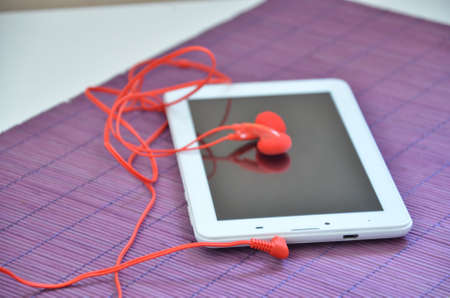 on a purple napkin white Tablet red headphonesの写真素材