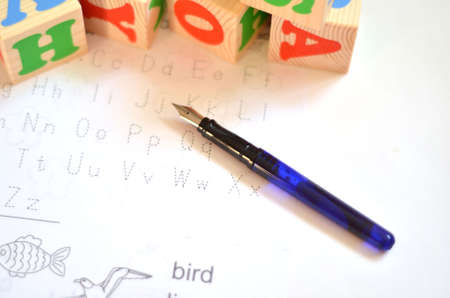 Selective focus of English letters with pen isolate on white background for study English concept. Cubes with lettersの写真素材