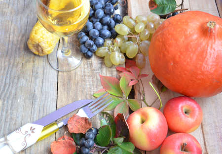 Autumn place setting. Thanksgiving dinner. Fall season fruit, pumpkins, plates, wine and candles. Thanksgiving dinnerの写真素材