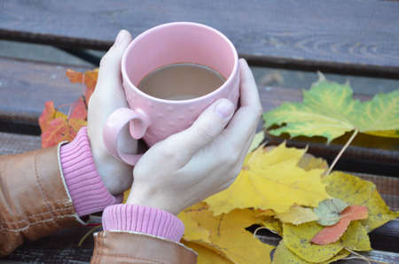 Cup of autumn tea (coffee, chocolate) and yellow dry leaves near, copy space. Hot drink for autumn cold rainy days. Hygge concept, autumn mood.の写真素材
