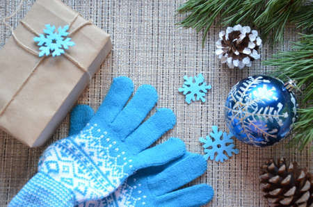 Christmas composition. Christmas gift, knitted blanket, pine cones, fir branches on wooden white background. Flat lay, top view, snowflakes christmas treats christmas decorationsの写真素材