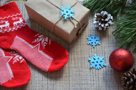Christmas composition. Christmas gift, knitted blanket, pine cones, fir branches on wooden white background. Flat lay, top view, snowflakes christmas treats christmas decorationsの写真素材