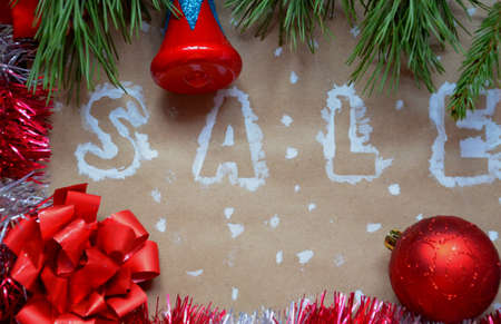 An inscription of a sale on a Christmas background. new year decoration. on kraft paper. Christmas boxes in snow with sale tag. christmas treeの写真素材