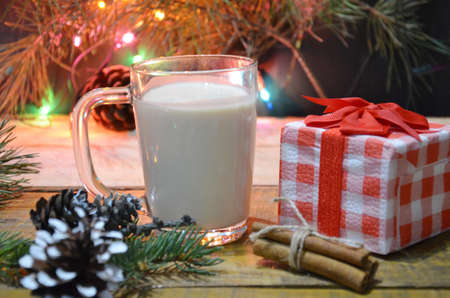 Home made Eggnog with cinnamon for Christmas and winter holidays. Against the backdrop of a Christmas tree with burning lights. New Year's Eveの写真素材