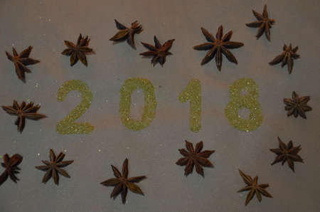 2018 with christmas decoration. concept of the new year and christmas. gold figures 2018 on the background of anise in the form of a flower background on kraft paperの写真素材