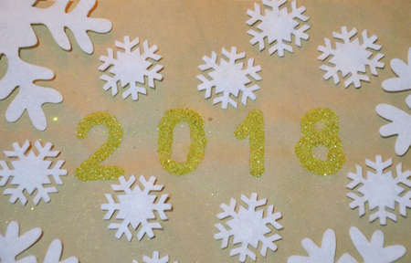 2018 with christmas decoration. concept of the new year and christmas. gold figures 2018 on the background of snowflakes on kraft paper.の写真素材