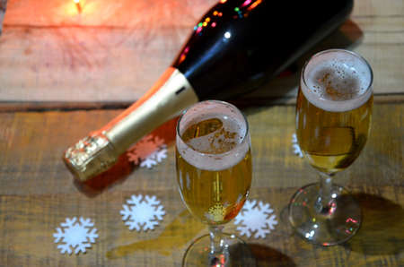 two glasses of champagne on the background of champagne. Christmas tree with Christmas lights. New Year and Christmasの写真素材