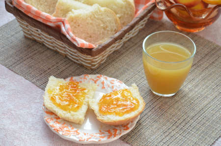 Healthy breakfast ingredients. Bowl of oat granola. beautiful fresh tasty Breakfast on the table. white bread toast basket sliced. sandwich with jam. peach juice. fresh fruit peaches.の写真素材