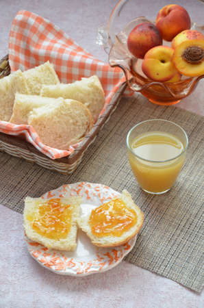 Healthy breakfast ingredients. Bowl of oat granola. beautiful fresh tasty Breakfast on the table. white bread toast basket sliced. sandwich with jam. peach juice. fresh fruit peaches.の写真素材