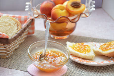 Healthy breakfast ingredients. Bowl of oat granola. beautiful fresh tasty Breakfast on the table. white bread toast basket sliced. sandwich with jam. peach juice. fresh fruit peaches.の写真素材