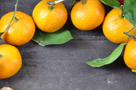 Tangerines oranges, mandarins, clementines, citrus fruits with leaves on the rustic wooden background, copy space. winter.の写真素材