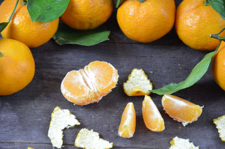 Tangerines oranges, mandarins, clementines, citrus fruits with leaves on the rustic wooden background, copy space. winter.の写真素材