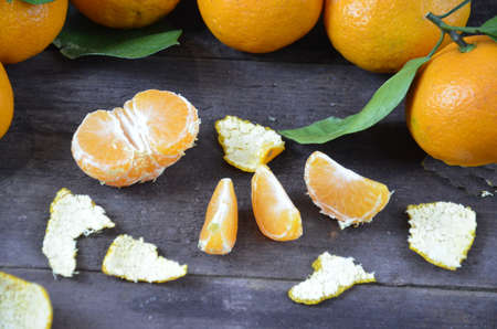 Tangerines oranges, mandarins, clementines, citrus fruits with leaves on the rustic wooden background, copy space. winter.の写真素材