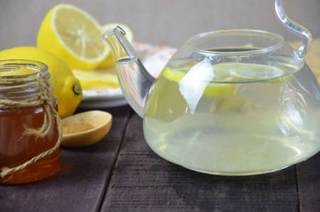 Cup of ginger tea with honey and lemon on wooden tableの写真素材