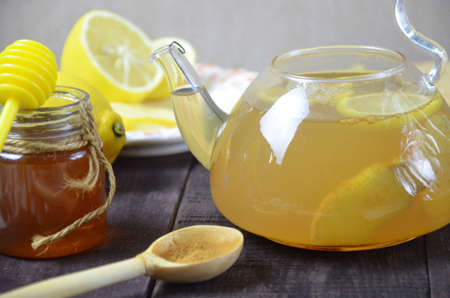 teapot of ginger tea with honey and lemon on wooden tableの写真素材